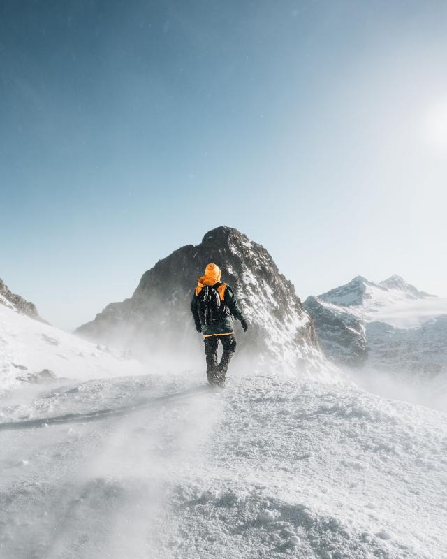 Een persoon op wandel in de bergen in de sneeuw 