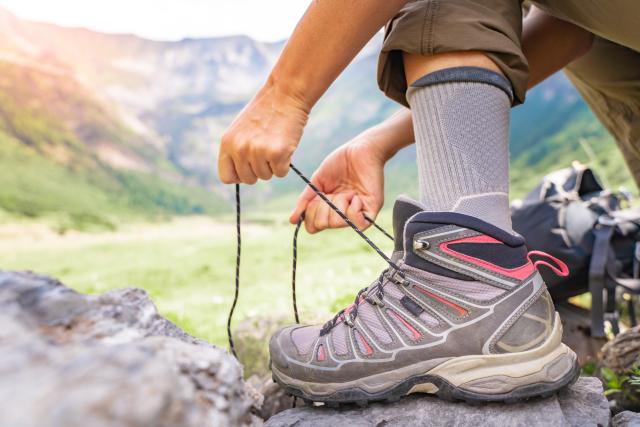 Persoon die de veters van wandelschoenen knoopt